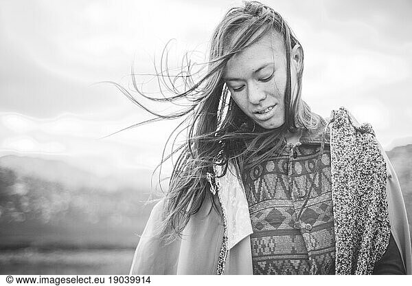 Girl smiles with wild hair in black and white