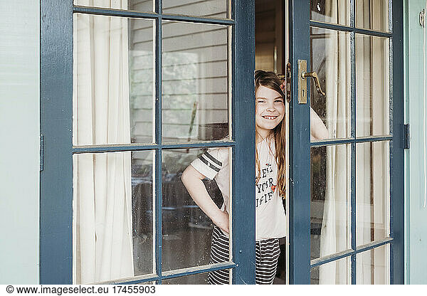Girl smiling and opening outside door