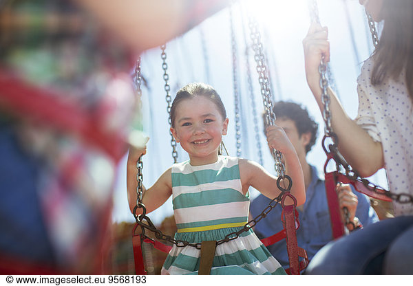 Girl smiling on carousel in amusement park
