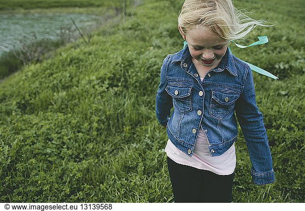 Girl smiling while walking on grassy field