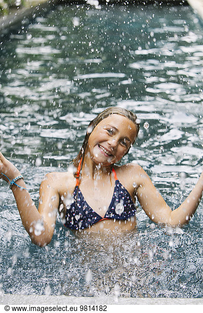 Girl splashing in swimming pool