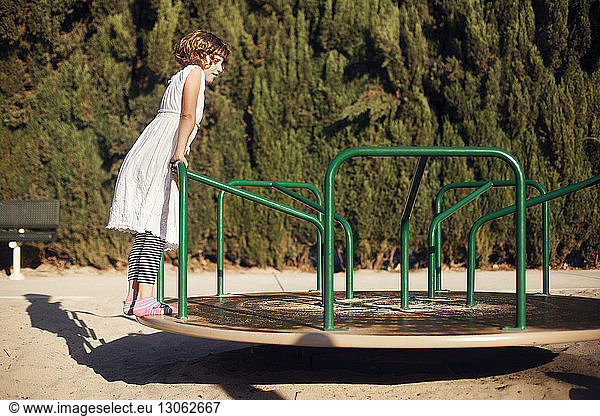 Girl standing on merry-go-round at park
