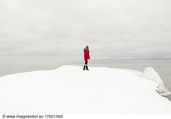Girl standing on snow looking at view in winter