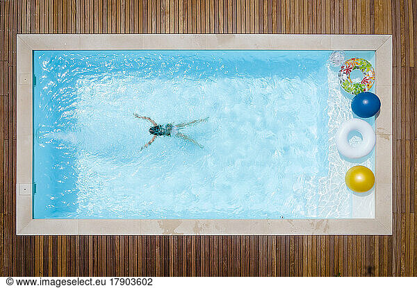 Girl swimming in pool on sunny day