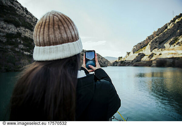 Girl taking a photo of a lake with her mobile