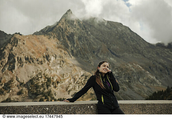 Girl talking on the phone with some mountains in the background
