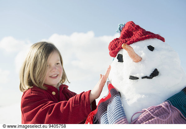 Girl touching snowman  smiling