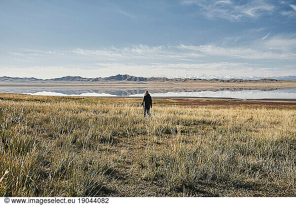 Girl traveler walks through the area near the lake TuzKol  wide shot