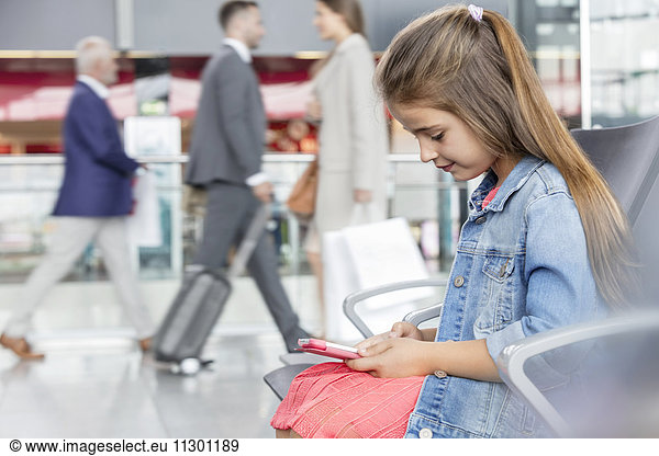 Girl using digital tablet in airport departure area