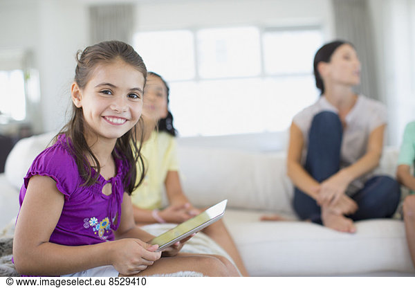 Girl using digital tablet on sofa in living room