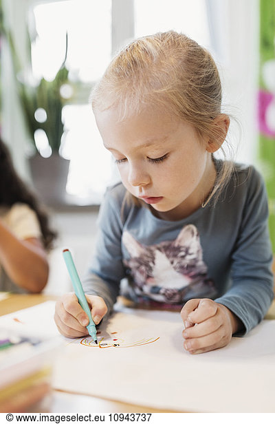 Girl using felt tip pen in drawing class