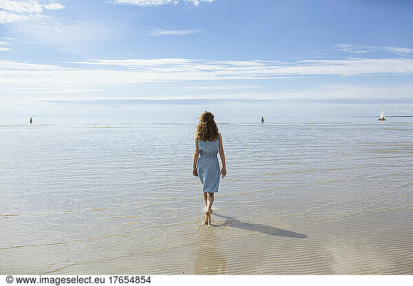 Girl wading on shore at beach