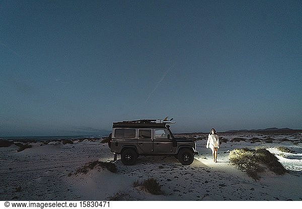 Girl walking close to the 4x4 during the blue hour