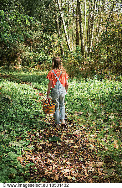 Girl walking in woods with basket