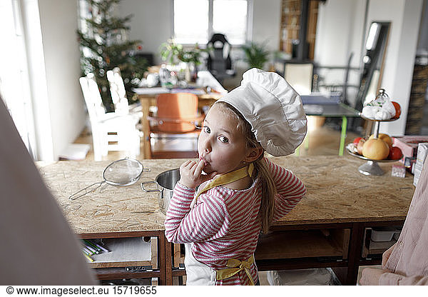 Girl wearing chef's hat in the kitchen