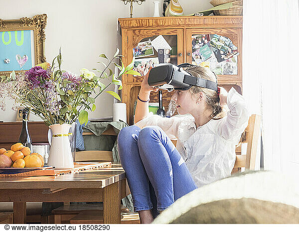 Girl wearing virtual reality glasses in living room
