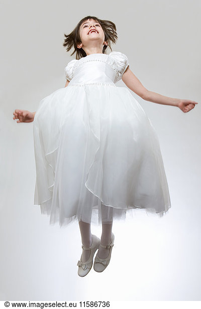 Girl wearing white dress jumping