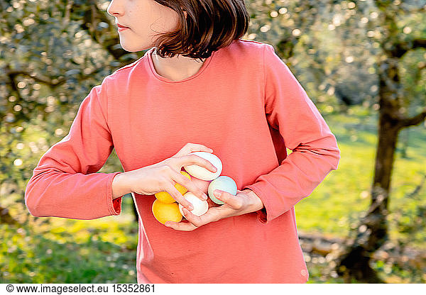Girl with a handful of dyed Easter eggs in orchard  mid section  Scandicci  Tuscany  Italy