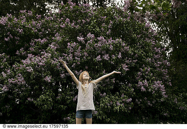 Girl with arms raised in nature