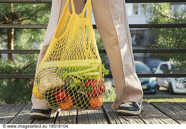 Girl with bag of various vegetables and fruits
