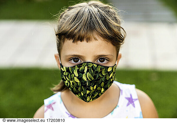 Girl with bangs wearing protective face mask outdoors