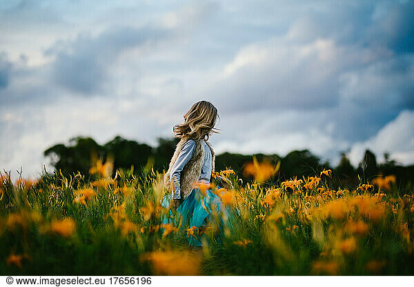Girl with blue skies and orange flower fields