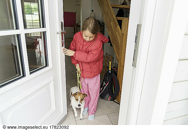 Girl with dog at entrance of house