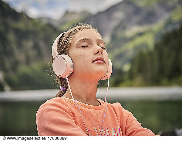 Girl with eyes closed listening music through headphones