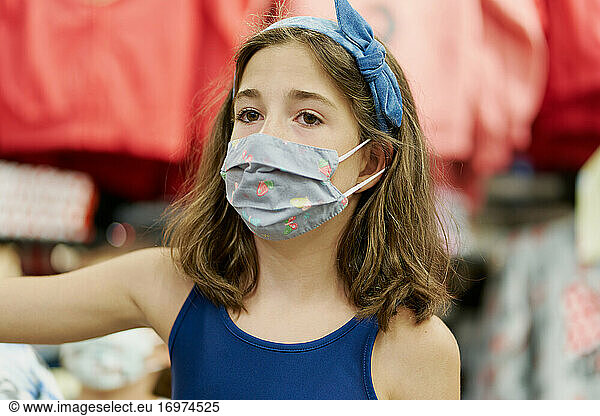 Girl with face mask shopping in clothes shop  coronavirus concep