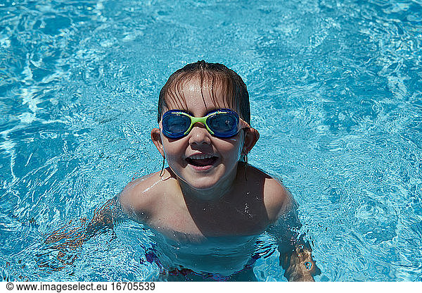 Girl with goggles in swimming pool