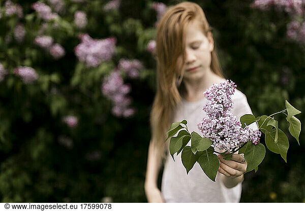 Girl with lilac flowers in nature