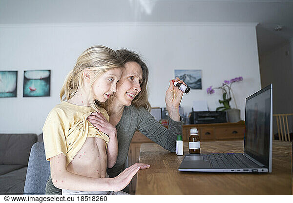 Girl with mother consulting doctor online