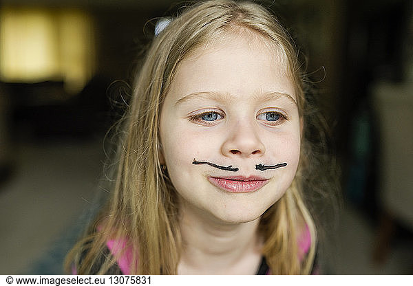 Girl with mustache face paint at home