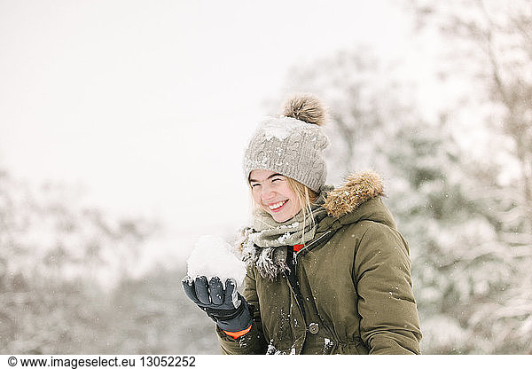 Girl with snow ball in winter landscape