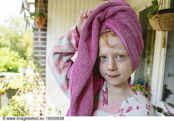 Girl with towel wrapped on head in balcony