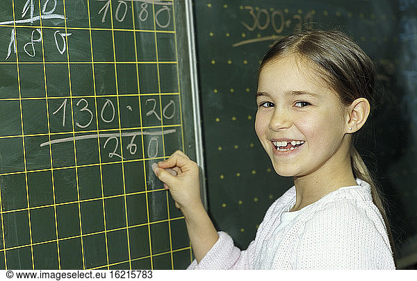 Girl writing on blackboard  portrait