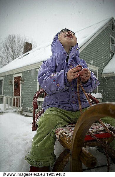 Girl  2-3 years  catching snowflakes with tongue.