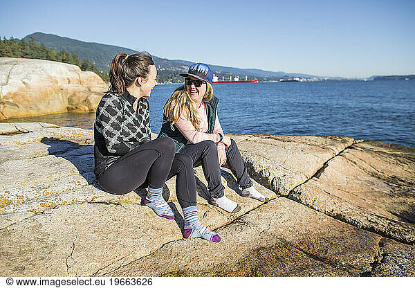 Girlfriends sit and catch up while at the beach in Vancouver.