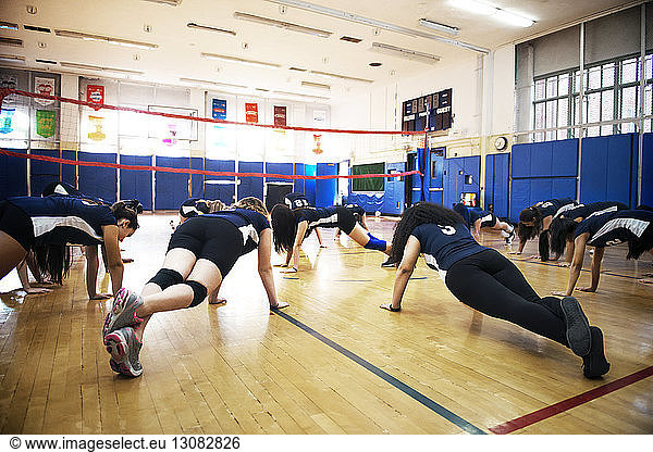 Girls doing warming up exercise on floor