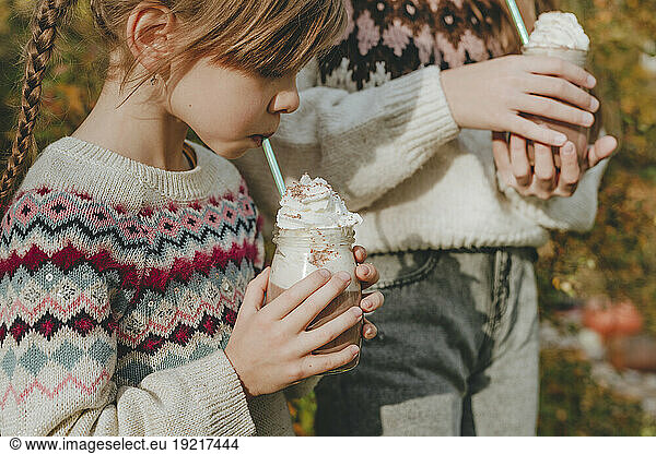 Girls drinking milkshake in garden