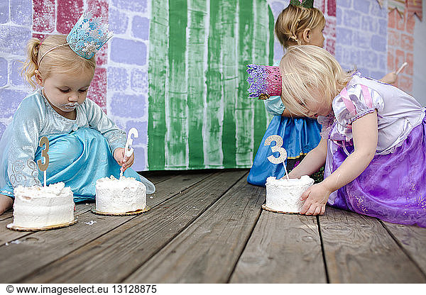 Girls holding cakes with number 3 during princess party