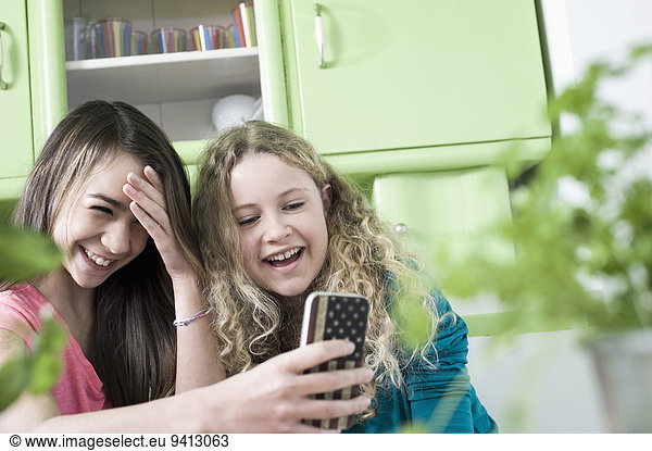 Girls in kitchen with smart phone