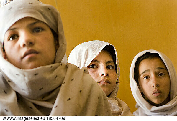 Girls in white head scarves attend an accelerated school program in Kabul.