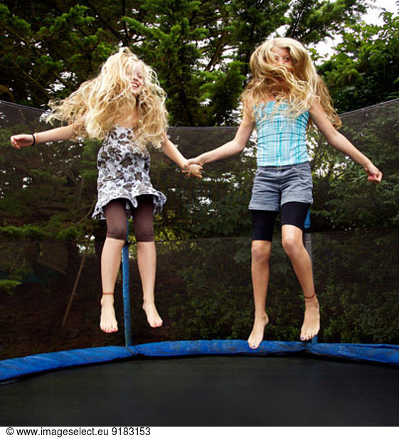 Girls jumping on trampoline outdoors
