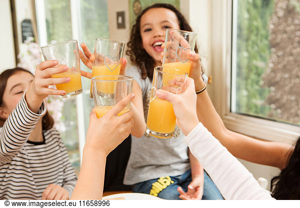 Girls making a toast with fruit juice