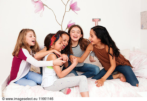 Girls on bed fooling around laughing