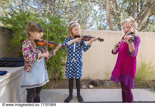 Girls playing violin outdoors