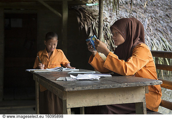 Girls revising before going to primary school  Pulau Siberut  Sumatra  Indonesia