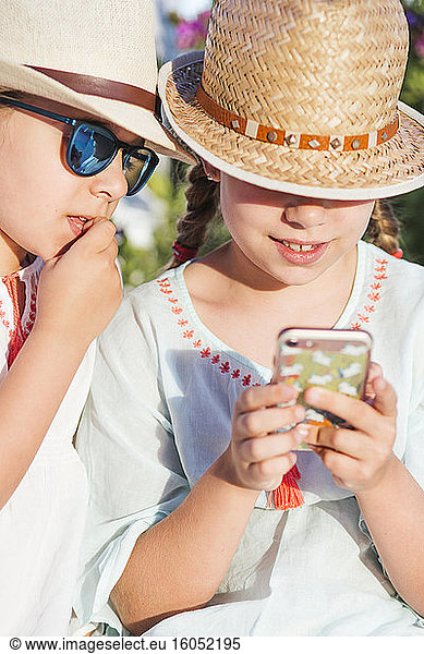 Girls using smart phone on sunny day