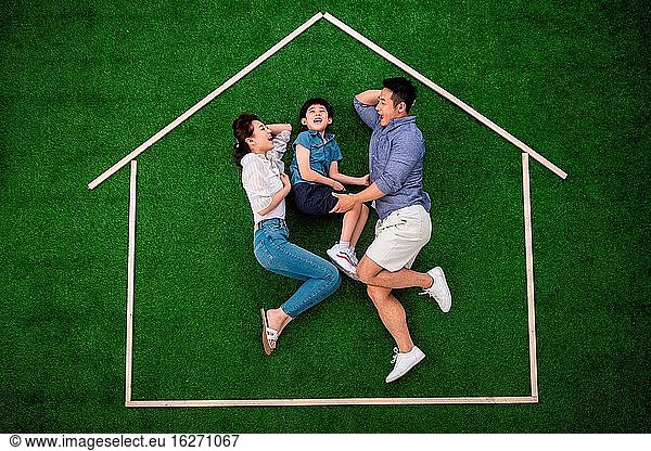 Glückliche drei lagen auf dem Rasen und spielten im Haus.
